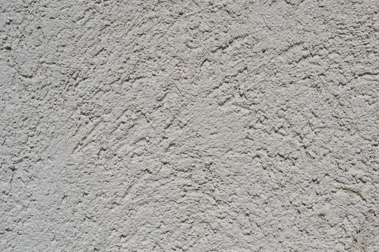 services-04 Close-up of a light gray stucco wall texture, ideal for backgrounds.