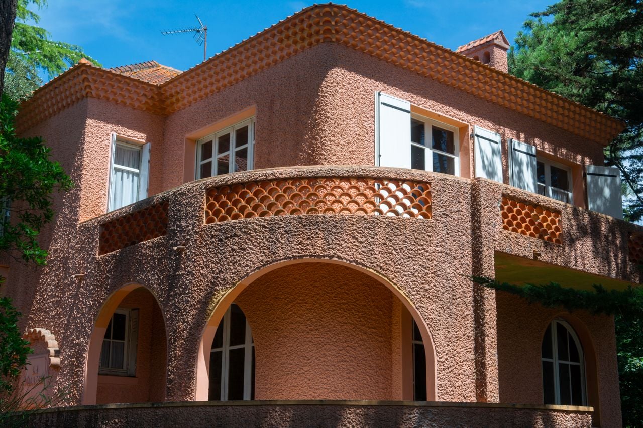 Beautiful pink villa with balcony in La Baule-Escoublac, France, under sunlight.
